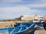 Small Wooden Fishing Boats on Seafront with White Buildings of the Medina Beyond, Essaouira Photographie par Pearl Bucknall