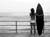 Model with Black Surfboard Standing on Boardwalk and Watching Wave on Beach Reprodukcja zdjęcia autor Images Monsoon Model with Black Surfboard Standing on Boardwalk and Watching Wave on Beach Reprodukcja zdjęcia autor Images Monsoon