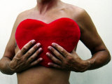 Man Holding Red Heart-Shaped Cushion in Front of His Naked Chest Photographic Print by Images Monsoon