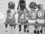 Four Young Baseball Players Wearing Sequential Numbers Lámina fotográfica por Images Monsoon