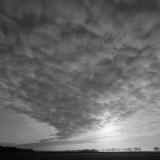 Clouds Obscure the Sun in a Huge Sky with Trees on the Horizon Photographic Print by Lynn Johnson