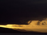 Dark Storm Clouds over the Galapagos Islands at Twilight Photographic Print by Mattias Klum