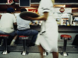 Waitress with a Tray Hurries Past in a Nw Washington, Dc Diner Photographie par Scott Sroka