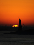 Sun Sets Behind the Statue of Liberty in New York Photographic Print