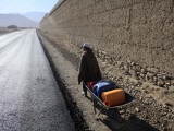 Child Uses a Wheel Barrow to Carry Jugs of Water, Logar Province, Afghanistan Photographic Print