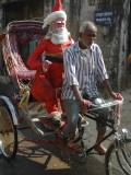 Indian Trishaw Driver Takes a Statue of Santa Claus to a Shop for Christmas Decoration in Agartala Photographic Print
