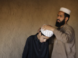 Afghan Refugee Teacher Adjusts the Turban for His Student Photographie