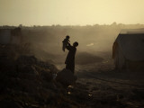 Displaced Man Holds His Baby Next to His Tent in Jalozai Refugee Camp Near Peshawar, Pakistan Fotografie-Druck