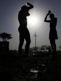 Indian Cycle Rickshaw Pullers Bathe by the Road Side on World Water Day in Allahabad, India Photographic Print