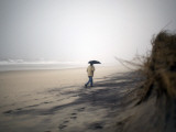 Beachgoer Walks Along an Eroded Section of Robert Moses State Park Beach in Babylon, New York Lámina fotográfica