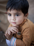 Boy Waits to Receive a Ration of Donated Rice at Food Distribution Center in Islamabad, Pakistan Photographie