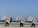 Workers Carry Beach Chairs Along the Beach of St. Peter-Ording at the North Sea, Northern Germany Photographic Print