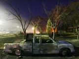 Truck Remnants in Front of a House Still Smoldering from a Grass Fire in a Small Town in Texas Lámina fotográfica