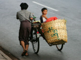 Young Myanmar Boy Looks on as He is Pushed Up a Hill Thursday in Downtown Yangon, Myanmar Lámina fotográfica