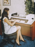 A Young Woman Office Worker Using What Now Looks Like a Rather Cumbersome Computer Photographic Print