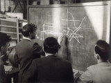 A Group of Scientists Study a Problem by Using Diagrams on a Blackboard Photographic Print by Henry Grant