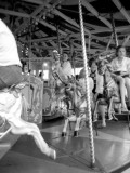 Children and Adults Ride a Carousel at a Funfair in Surrey Photographic Print by Vanessa Wagstaff