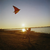 Boy Flying a Kite at Sunset Photographic Print by Dennis Hallinan