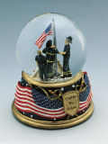 Close-Up of Figurines of Firefighters Standing Near a Flag in a Snow Globe Photographic Print