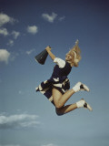 Cheerleader Jumping Holding Megaphone Photographic Print by Dennis Hallinan