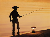 Boy Pole Fishing by Shoreline with an Oil Lamp Photographic Print by Dennis Hallinan