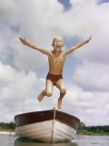 Boy Jumping Off Bow of Boat into Water Photographic Print by Dennis Hallinan