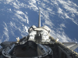 A Partial View of Space Shuttle Atlantis Backdropped by a Blue and White Earth Lámina fotográfica