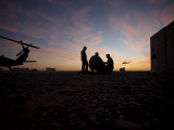 A UH-60 Black Hawk Crew Carry Out a Mission Brief at Sunset Photographic Print