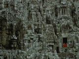 Serene Stone Faces Smile on Two Robed Monks Who Peer from Temple Photographic Print by W.E. Garrett