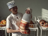 A Nurse Holds a Tightly Wrapped Newborn Baby Photographic Print by Dean Conger