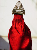 Woman Draped in Red Chadri Carries Goldfinches in a Cage on Her Head Photographie par Thomas J. Abercrombie