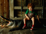 A Five Year Old Boys Sits on a Dead 10-Foot Long Alligator Photographie par Joel Sartore