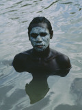 Aboriginal Teen with a Mask of Mud, Swimming in a Billabong Photographie par Sam Abell