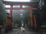 Tourists with Umbrellas Walk under an Arch at the Base of Mount Fuji Photographie par Karen Kasmauski