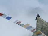 Mountain Climber Alex Lowe Sits on a Rock Near Tibetan Prayer Flags Photographie par Gordon Wiltsie