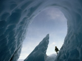 A Climber Stands Near the Opening of an Ice Cave Photographie par George F. Mobley