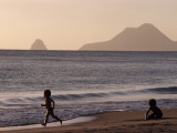 A Child Running and Another Playing on a Beach Along the Shoreline Photographie par Jodi Cobb