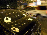A Display of Lights Reflected on a Car Photographie par Jodi Cobb