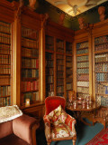 A Red Chair Sits Amid Shelves of Books in Balfour Castle's Library Photographic Print by Jim Richardson