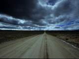 Dark Storm Clouds over Dirt Road and Grasslands of Saskatchewan Photographic Print by David Edwards