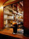A Pint of Dark Beer Sits in a Pub Service Window Photographic Print by Jim Richardson