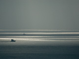 Boats Silhouetted Against a Glittering Ocean Photographie par Jodi Cobb