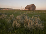 An Abandoned House Sits Near White Butte in the Grasslands Photographic Print by Phil Schermeister