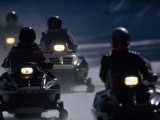 Snowmobilers Ride Down a Snowy Road in Yellowstone Park Impressão fotográfica por Raymond Gehman