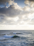 A Lone Wave Breaks as the Clouds Glow at Sunset Photographie par Michael Hanson