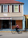 Man Riding Bike Through Black River Town Lámina fotográfica por Greg Johnston