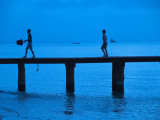 Two Boys Walking on Occidental Grand Cozumel Resort Pier at Sunset Photographic Print by Dennis Johnson