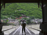 Man Carrying Basket on Luding Iron Chain Bridge over Dadu River Photographie par Keren Su