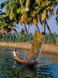 Man Paddling Small Canoe with Sail Near Ayiramthengu Photographic Print by Craig Pershouse