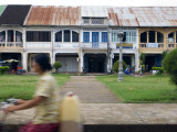 Riding Past French Colonial-Era Shophouses Fotografisk trykk av Austin Bush Riding Past French Colonial-Era Shophouses Fotografisk trykk av Austin Bush